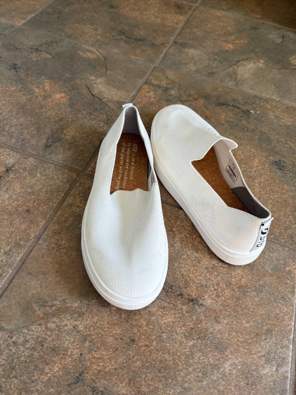STQ white slip-on canvas sneakers featuring a cork-accented insole